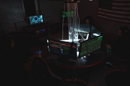 Equipe de profissionais acompanha dados e sistemas em computadores de uma sala de operações de cibersegurança.