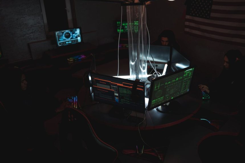 Equipe de profissionais acompanha dados e sistemas em computadores de uma sala de operações de cibersegurança.